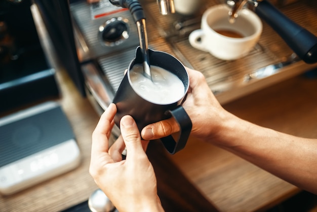 Barista masculino prepara bebidas en la máquina de café