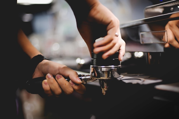 El barista prensa café molido usando una vista de primer plano de manipulación en las manos