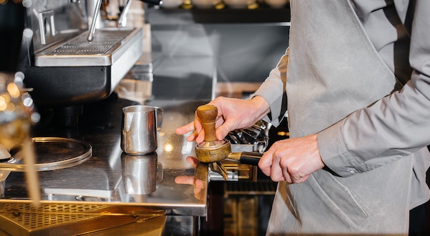 El barista prepara café en una cafetería moderna.