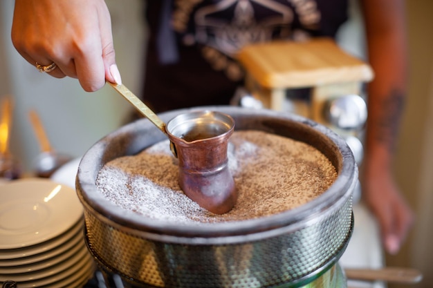 Un barista prepara café en una tetera