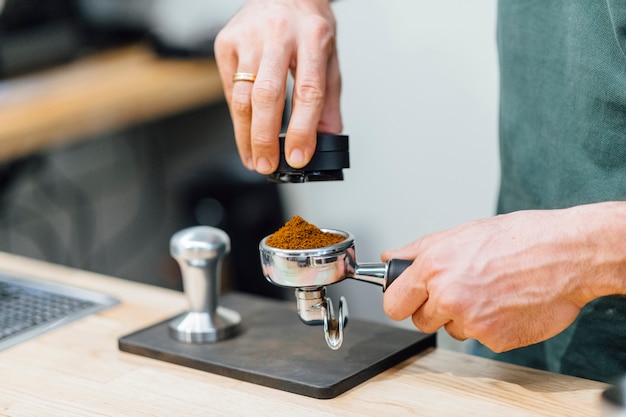 Barista pressionando café para portafilter