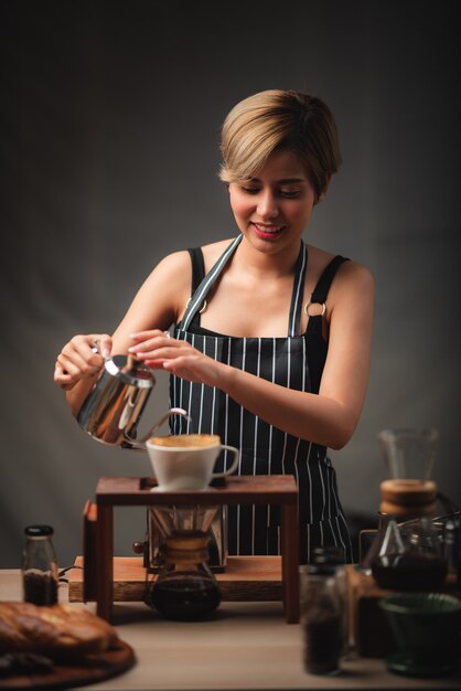 Barista profesional preparando y preparando café con chemex verter sobre cafetera y hervidor de goteo. mujer joven haciendo cafe
