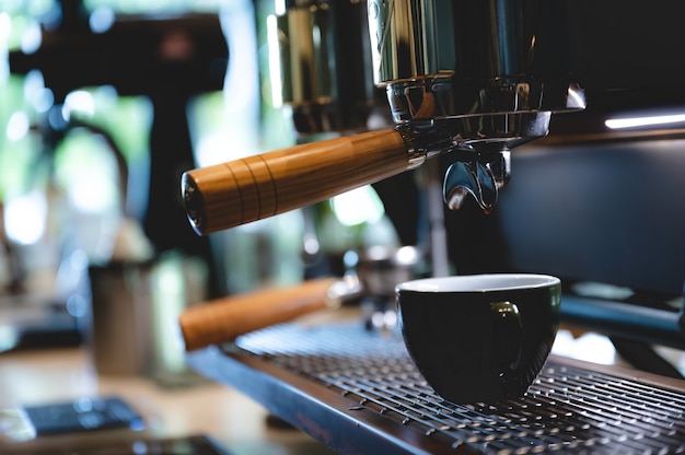 Barista profissional fazendo café expresso para uma xícara de bebida no café, máquina de bebida com cafeína, pessoa servindo água quente com a mão, negócios no café da manhã, aroma fresco na bebida quente