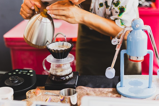 Foto barista profissional preparando café usando chemex derramando sobre a cafeteira e a chaleira de gotejamento