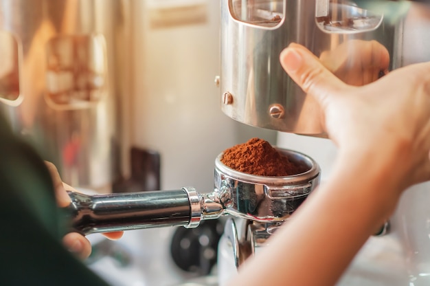 Barista segurando a adulteração de pressionar café moído