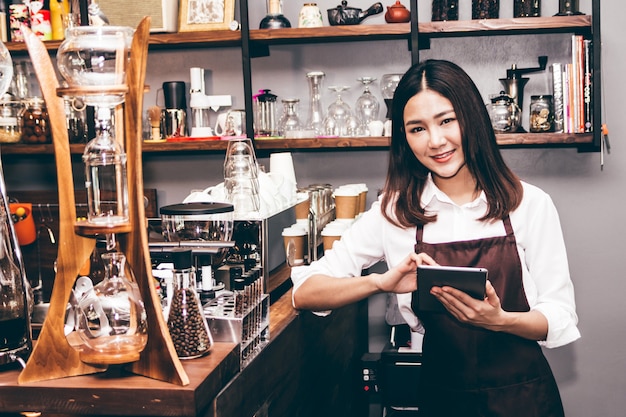 Barista segurando o tablet na cafeteria