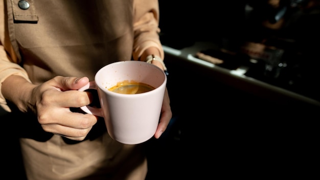 Barista segurando uma xícara de café na cafeteria de perto