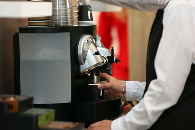 Barista sirviendo café en una cafetera moderna