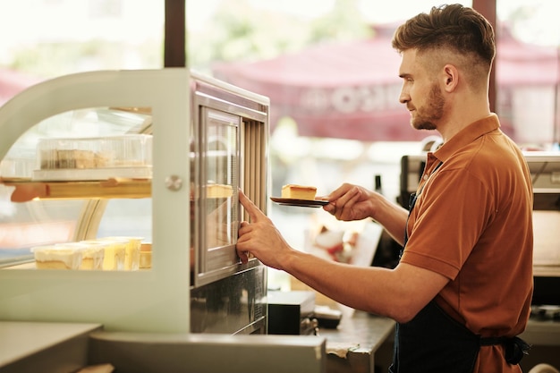 Barista tomando prato com bolo