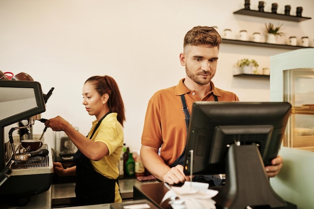 Foto barista trabajando en el mostrador de caja