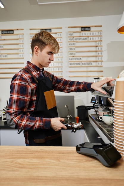 Barista usando cafeteira para fazer café