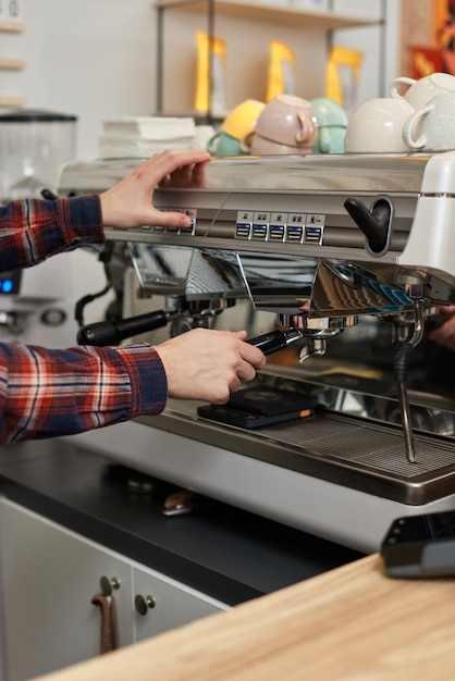 Barista usando cafeteira para fazer café