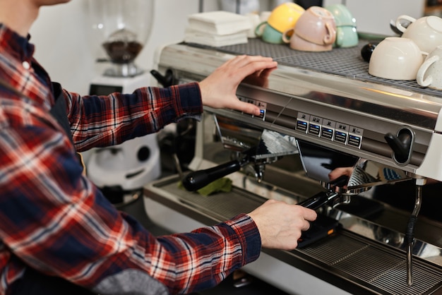 Barista usando cafeteira para fazer café