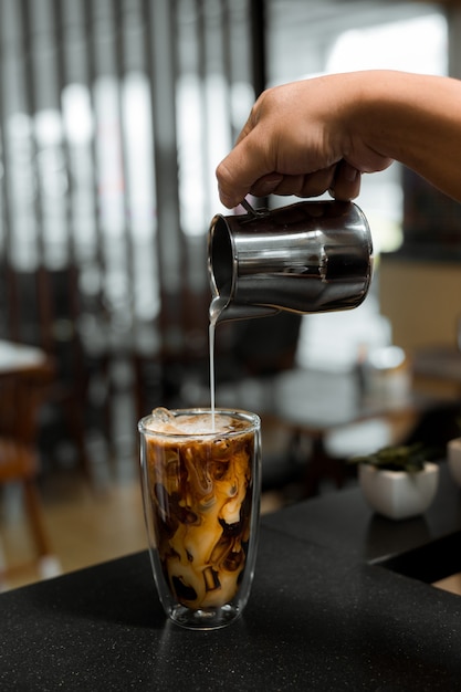 Barista vertiendo café en vaso