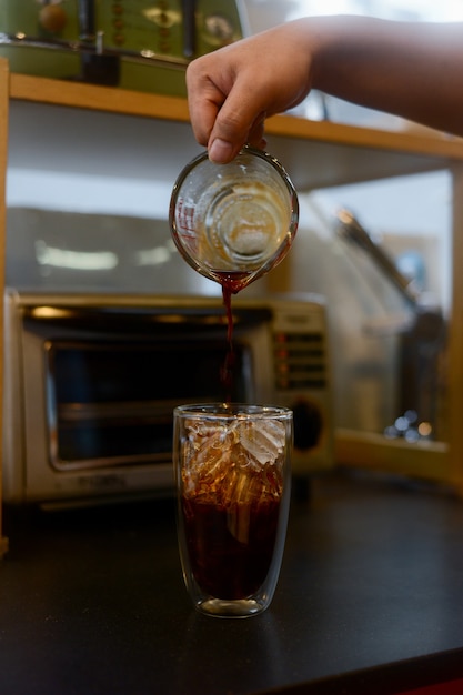 Barista vertiendo café en vaso