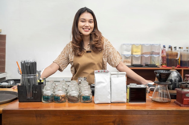 Baristas asiáticas em pé atrás do balcão