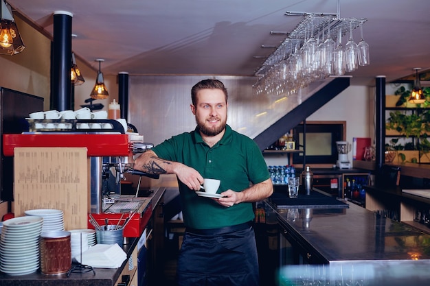 Barkeeper Barista mit Kaffee in der Hand hinter der Bar.