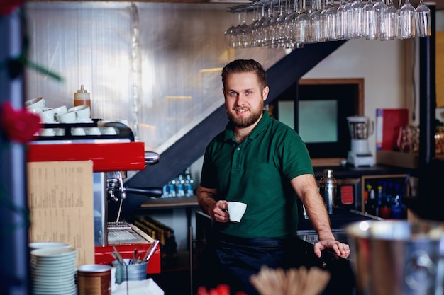 Barkeeper Barista mit Kaffee in der Hand hinter der Bar