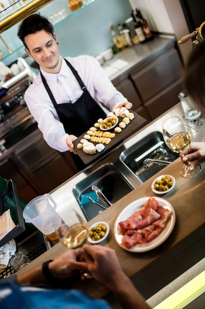 Barkeeper, der den Kunden an der Theke Essen serviert