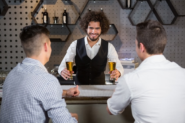 Barkeeper, der seinen Kunden Bier serviert