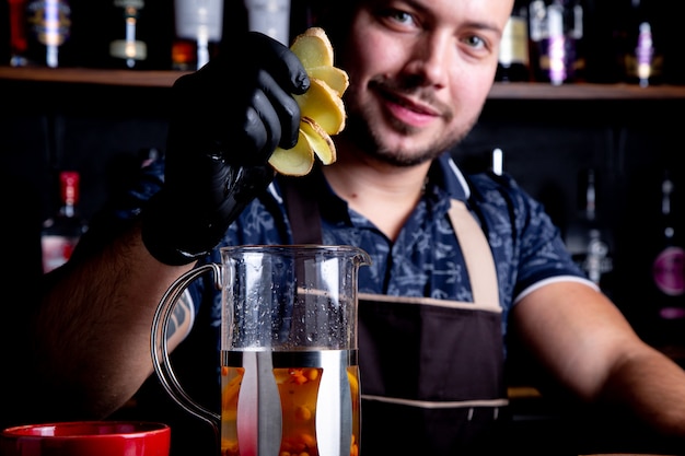 Barkeeper fügt geschnittenen Ingwer in den Kessel, um Tee zu brauen