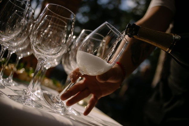 Barkeeper gießt auf einer Party Champagner in Gläser. Party- und Feiertagsfeierkonzept.