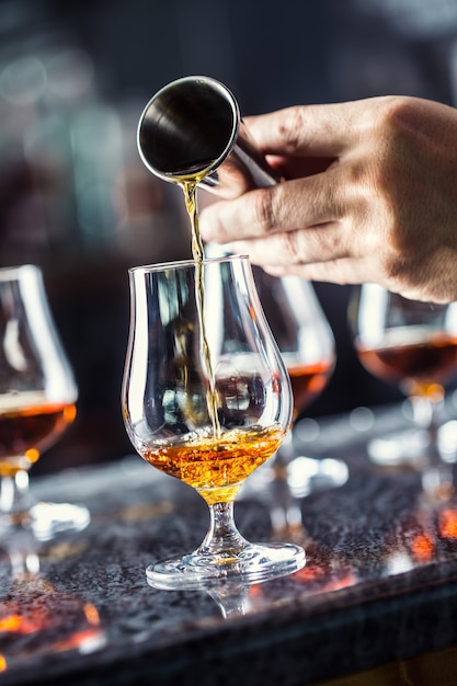 Barkeeper Hand gießt alkoholisches Getränk im Nachtclub, in der Bar oder in der Kneipe.