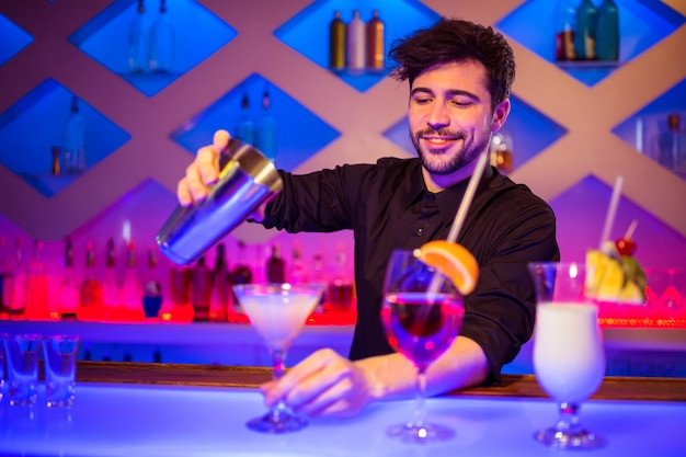 Barkeeper lächelt beim Vorbereiten des Cocktails