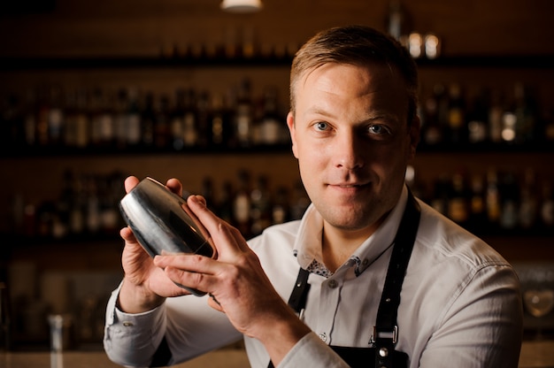 Barkeeper macht einen Cocktail mit einem Shaker