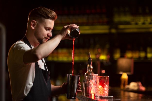 Foto barkeeper macht einen cocktail mit einem shaker