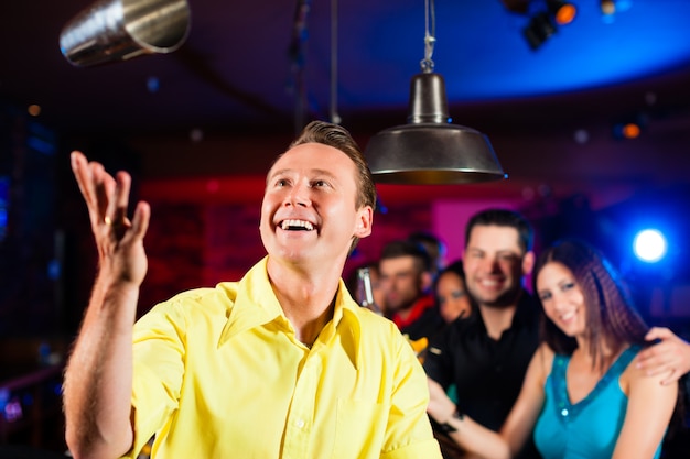 Barkeeper en un pub está mezclando cócteles o bebidas.