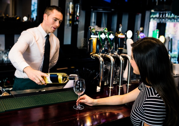 Barkeeper serviert ein Glas Wein in einer Bar