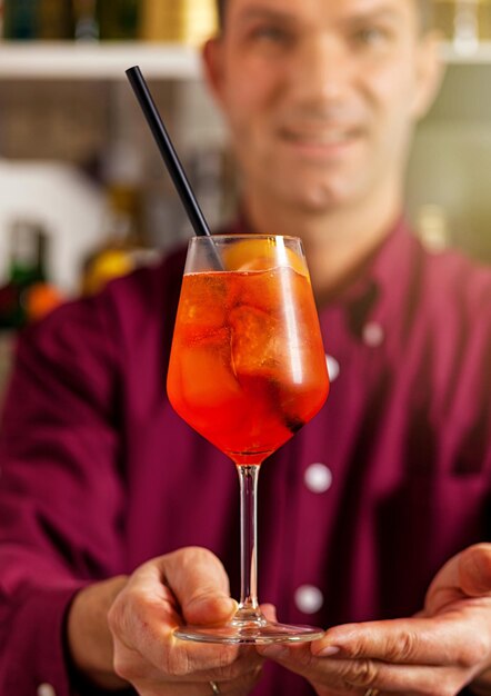 Foto barman a apresentar um cocktail aperol spritz