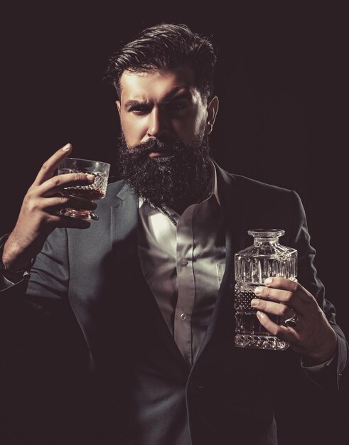 Foto barman atraente no bar de uísque elegante homem rico segurando um copo de uísque velho com barba ho