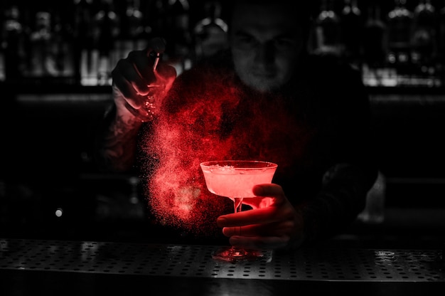 Foto barman borrifando o delicioso coquetel do vaporizador especial no balcão do bar