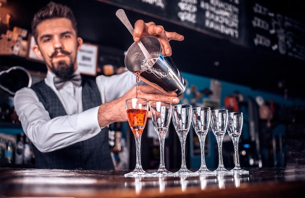 Barman confiado hace un espectáculo creando un cóctel en la discoteca