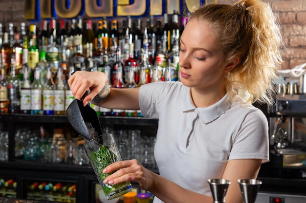 Barman de mulher fazendo um coquetel de álcool