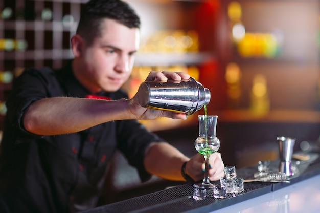 Barman, derramando cocktail fresco em copo chique