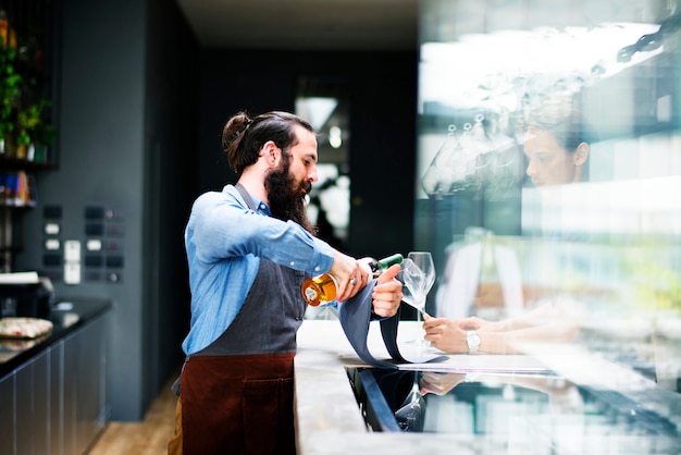 Barman, derramando um vinho para o copo