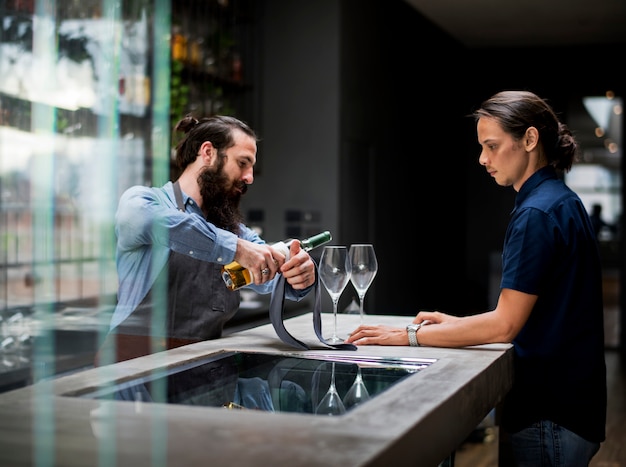 Barman, derramando um vinho para o copo