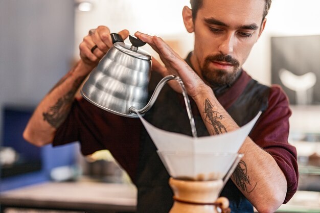 Barman despejando água quente no gotejador