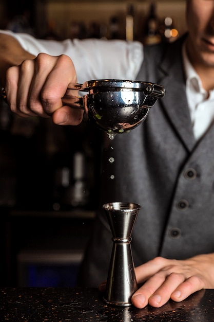 Barman espremendo suco para uma coqueteleira