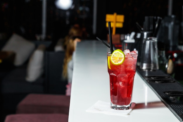 Barman está fazendo um cocktail no bar balcão da boate