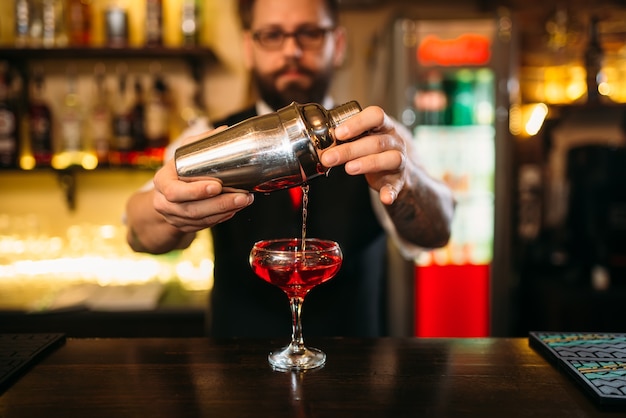 Barman está haciendo cóctel de alcohol en el mostrador