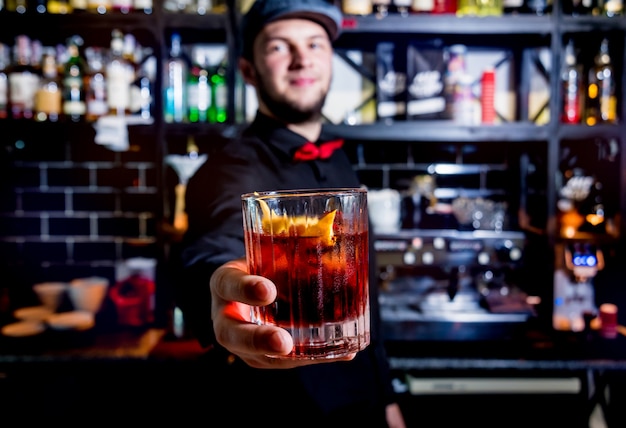 El barman está haciendo un cóctel en la barra del bar. Cócteles frescos