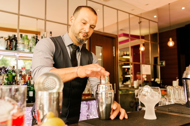 Barman experto está haciendo cócteles en el club nocturno