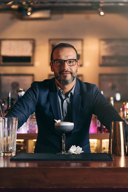 Barman experto está haciendo cócteles en el club nocturno.