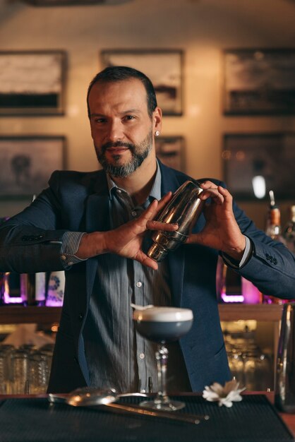 Barman experto está haciendo cócteles en el club nocturno.