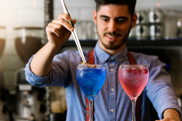 Foto barman experto está haciendo cócteles en la discoteca.