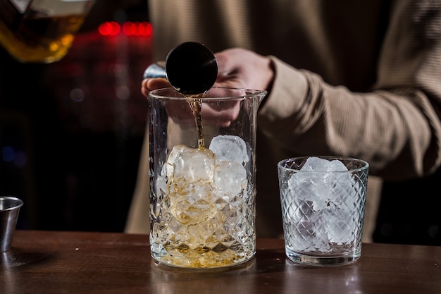 Barman hacer cóctel de alcohol en barra de bar. Barman haciendo cóctel de jugo de la selva en el bar